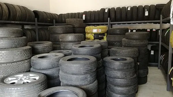 Стеллажи с новыми и подержанными шинами в шинном магазине
